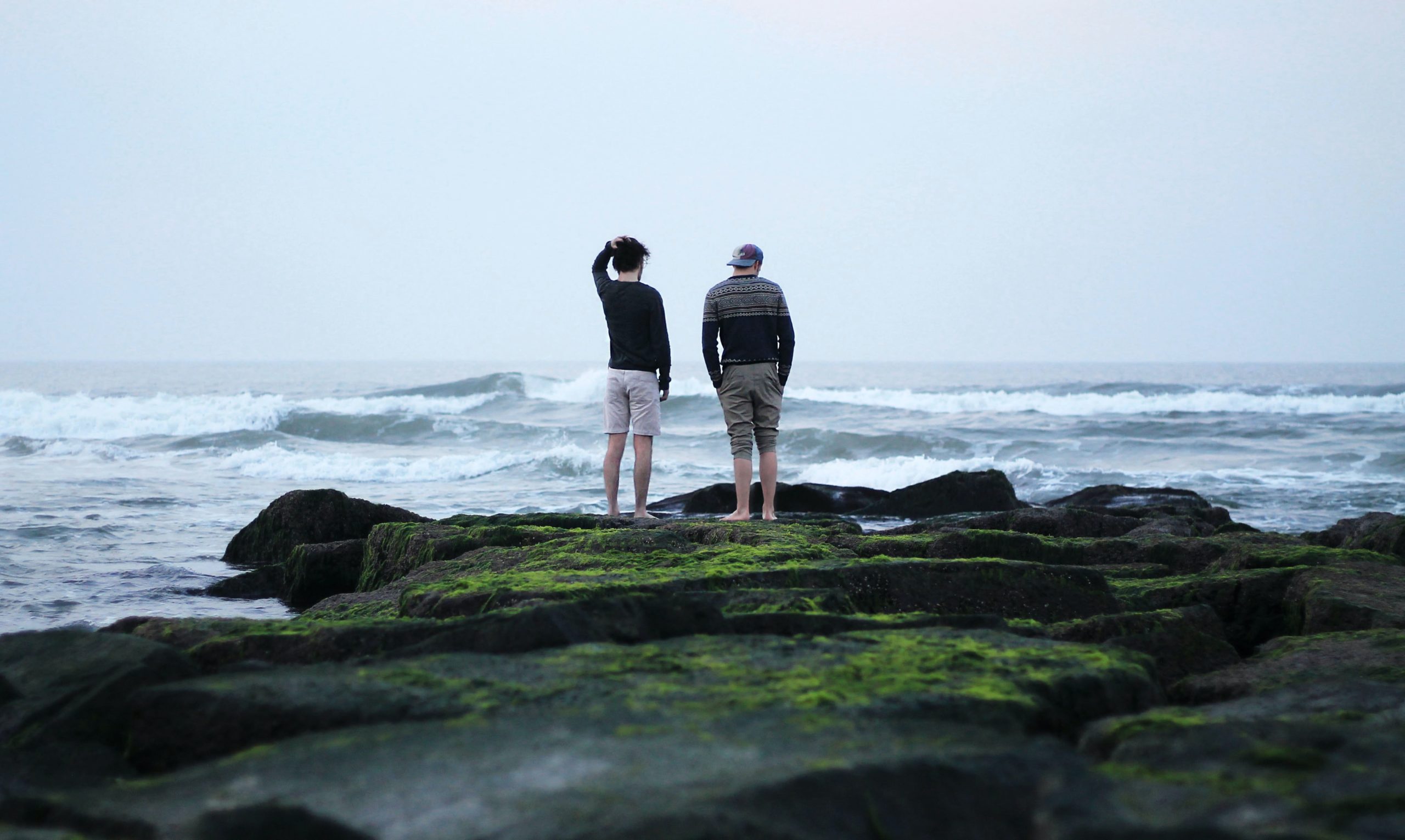 Two men talking on the beach.